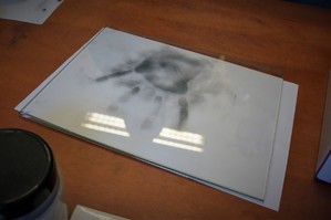 Wykonany przez uczennicę ślad daktyloskopijny, odcisk dłoni na białej kartce