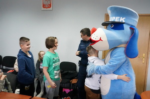 Na zdjęciu widzimy jak chłopiec przytula się do Sznupka - maskotki Śląskiej Policji